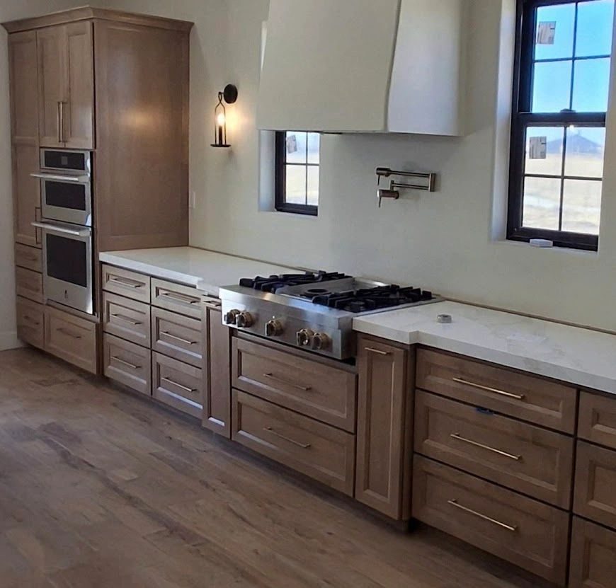 Custom stained wood kitchen cabinetry with a professional range and hood, built by Knotty Otters Custom Woodwerx
